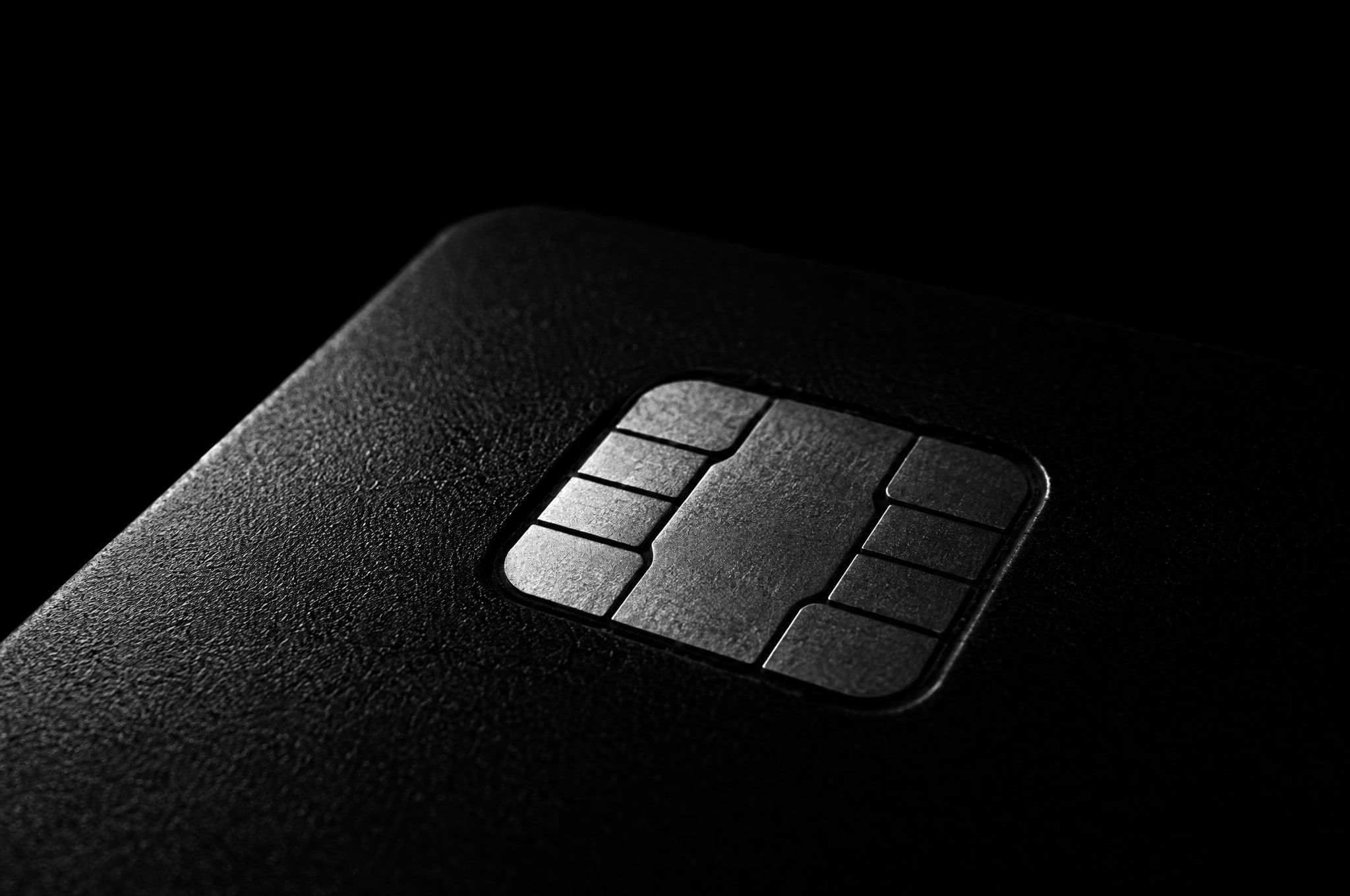 A sealed black security chip, lit from the side